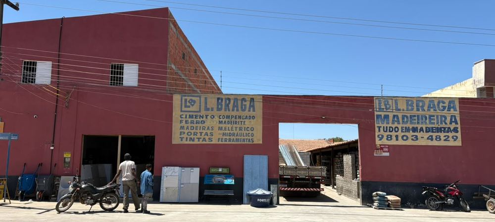 Fachada da loja Santa Luzia: prédio vermelho com letreiros L BRAGA e portão de carga